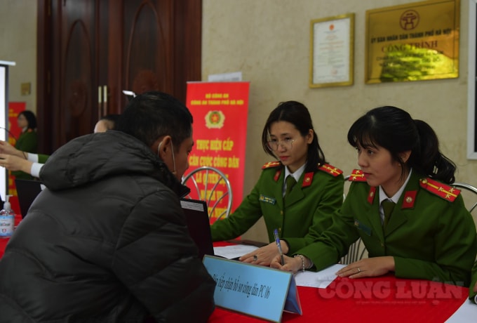 Cán bộ công an kiểm tra thông tin, giấy tờ của người dân.