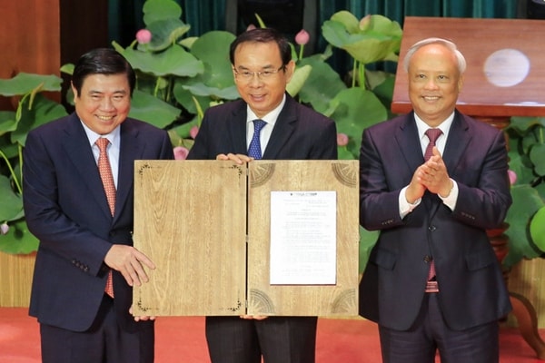 Phó Chủ tịch Quốc hội Uông Chu Lưu (phải) trao Nghị quyết cho lãnh đạo Thành uỷ, UBND TP Hồ Chí Minh. Ảnh: VNE