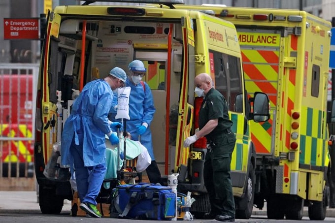 Một bệnh nhân nhiễm Covid-19 được đưa lên xe cứu thương ở London, Anh. Ảnh: Reuters