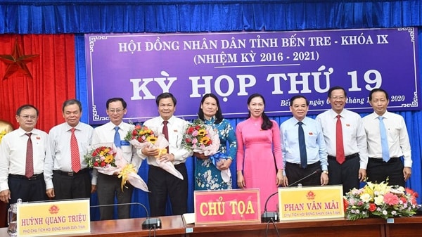 Ông Nguyễn Minh Cảnh (thứ 3 từ trái qua) và bà Nguyễn Thị Bé Mười (đứng giữa) nhận hoa chúc mừng từ lãnh đạo tỉnh Bến Tre hôm 9/12/2020