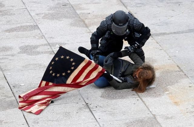 Một phụ nữ tham gia bạo loạn ở điện Capitol bị cảnh sát bắt giữ. Ảnh: Reuters