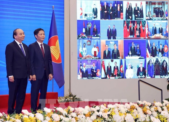 Thủ tướng Nguyễn Xuân Phúc, Chủ tịch ASEAN 2020 và Bộ trưởng Bộ Công thương Trần Tuấn Anh và các nước tham dự lễ ký Hiệp định Đối tác Kinh tế Toàn diện Khu vực RCEP. Ảnh: Thống Nhất - TTXVN.