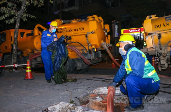 Trên con đường Nguyễn Tuân (quận Thanh Xuân, Hà Nội) có khoảng 10 người công nhân cùng các xe chuyên dụng đang chuẩn bị nhiệm vụ nạo hút cống,