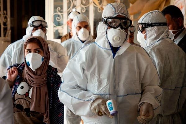 Các nhân viên y tế Iran đo nhiệt độ cho người qua lại khu vực biên giới. Ảnh: New York Times