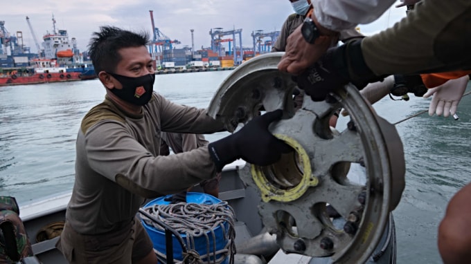 Các nhân viên cứu hộ trục vớt thiết bị của chiếc máy bay gặp nạn - Ảnh: AFP
