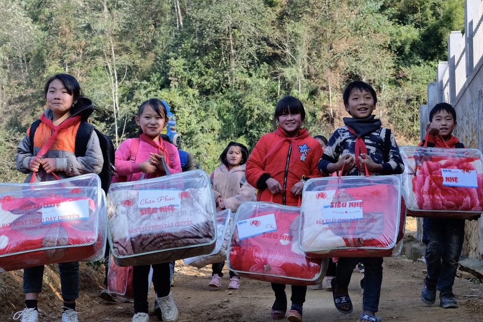 Các em học sinh Trường phổ thông dân tộc bán trú, tiểu học số 2 Quan Hồ Thẩn hạnh phúc khi nhận được chăn ấm và quà. Ảnh: Nam Trần