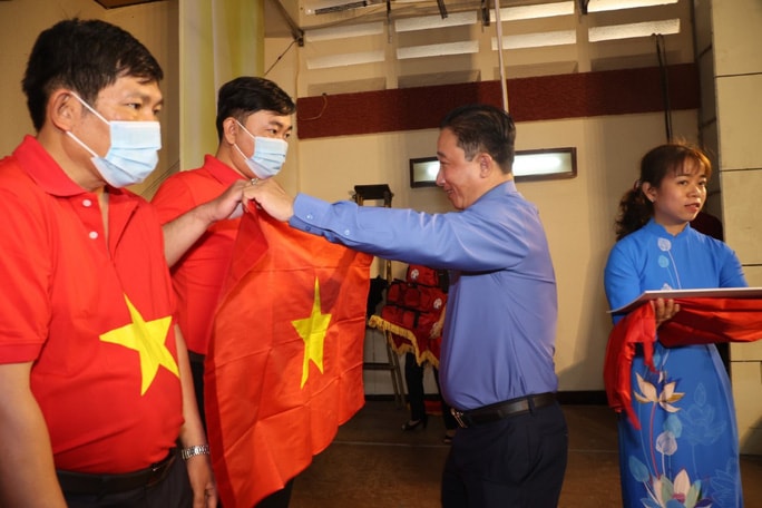 Ông Bùi Thanh Liêm, Phó Tổng Biên tập Báo Người Lao Động, trao cờ Tổ quốc cho đại diện các nghiệp đoàn khai thác hải sản. Ảnh: Quang Liêm