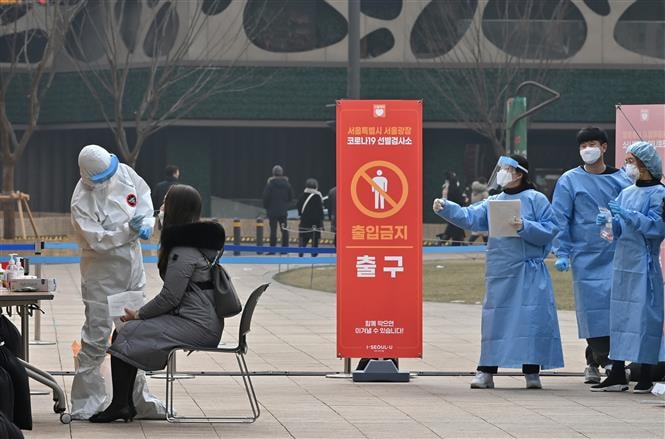 Nhân viên y tế lấy mẫu xét nghiệm COVID-19 cho người dân tại Seoul, Hàn Quốc ngày 23/12/2020. Ảnh: AFP/TTXVN