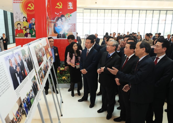 Thường trực Ban Bí thư Trần Quốc Vượng, Trưởng Ban Tuyên giáo Trung ương Võ Văn Thưởng và đại biểu tham quan Trưng bày ảnh Vững bước dưới cờ Đảng quang vinh do Ban Tuyên giáo Trung ương và Thông tấn xã Việt Nam tổ chức. (Ảnh: TTXVN)