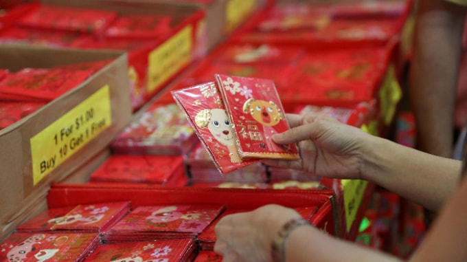 Một khách hàng chọn phong bao lì xì cho Tết Nguyên đán ở khu phố Tàu của Singapore năm 2018. Ảnh: Reuters
