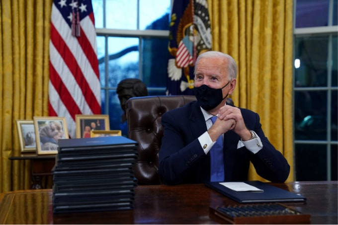 Tổng thống Biden ngồi trong Phòng Bầu dục trong ngày đầu tiên tại Nhà Trắng. Ảnh: Getty