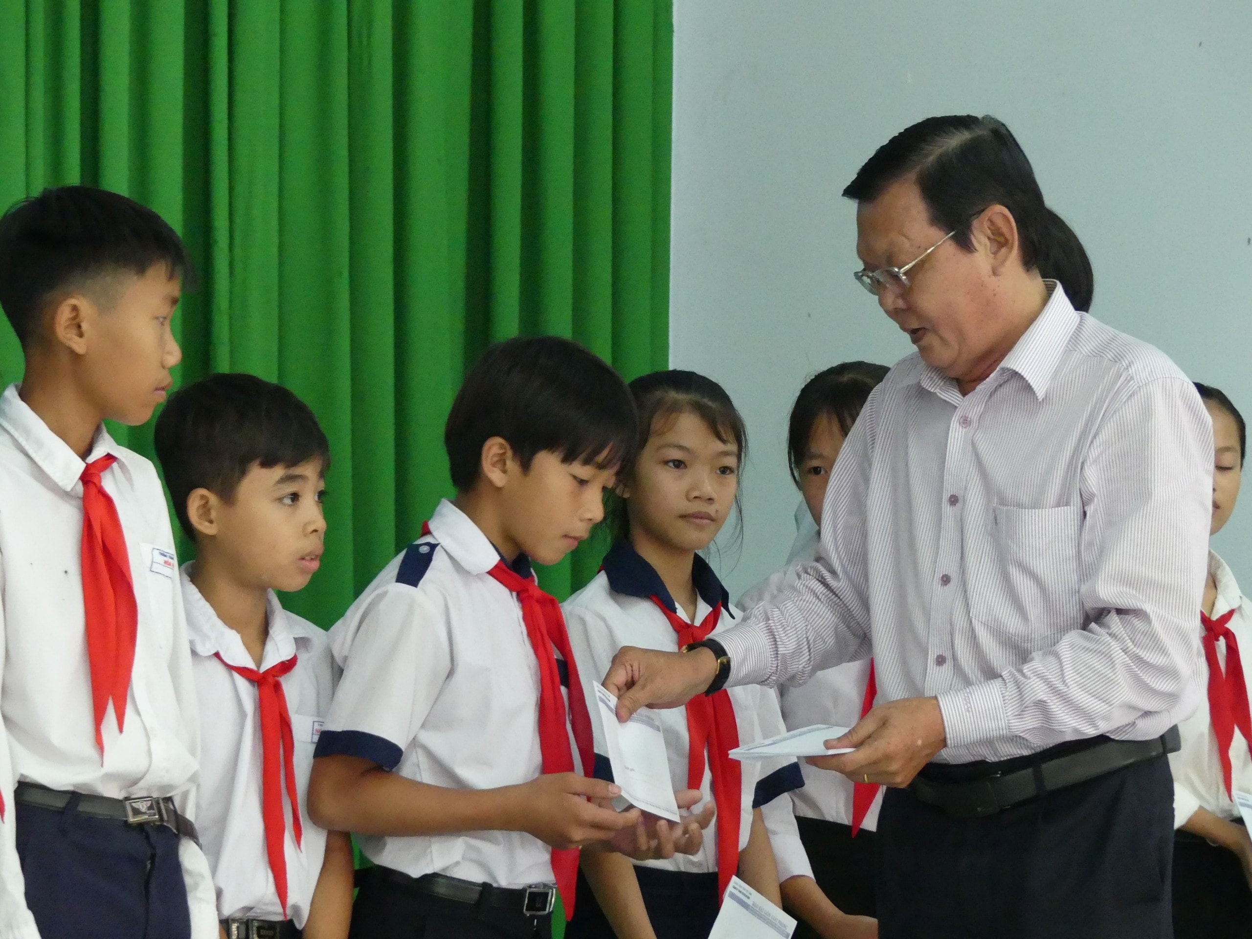 Nhà báo Nguyễn Tấn Phong, Phó Chủ tịch Hội Nhà báo TPHCM trao học bổng cho học sinh. Ảnh: Việt Nga