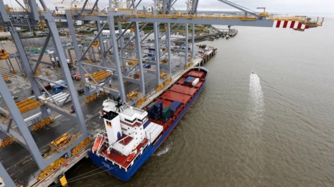 Một con tàu container được neo bên cạnh một cần trục trên bờ biển tại cảng container DP World London Gateway ở Essex, miền nam nước Anh. Ảnh: Reuters