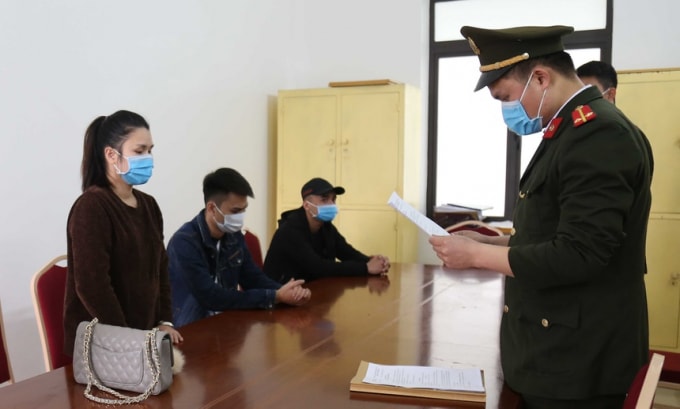 Công an đọc quyết định xử phạt nhóm người khai báo y tế gian dối. (Ảnh: Công an cung cấp).