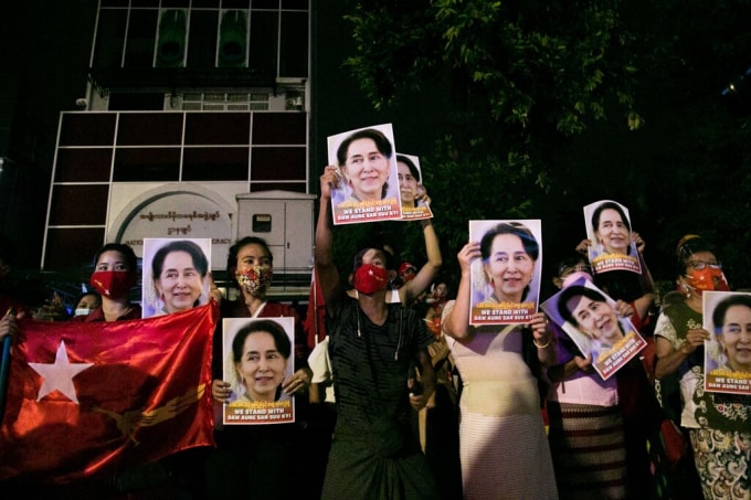 Người dân giơ ảnh và biểu ngữ ủng hộ bà Aung San Suu Kyi. Ảnh: NYT