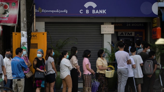 Đám đông người dân xếp hàng bên ngoài một cây ATM để rút tiền. Ảnh: Reuters