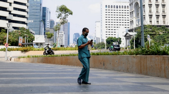 Một người đàn ông đi dạo trong khu thương mại yên tĩnh ở Jakarta vào ngày 8 tháng 6 năm 2020. © Reuters