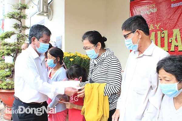 Đồng chí Nguyễn Tôn Hoàn, Tổng biên tập Báo Đồng Nai tặng quà cho các hộ gia đình có hoàn cảnh khó khăn. Ảnh: Nga Sơn