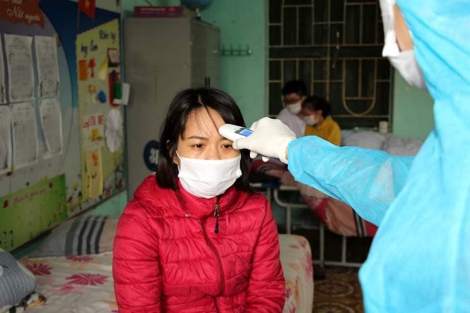 Y sĩ Khánh đang làm nhiệm vụ đo thân nhiệt cho cô giáo tại điểm cách ly trường tiểu học Lai Cách, Cẩm Giàng, Hải Dương (ảnh TL).