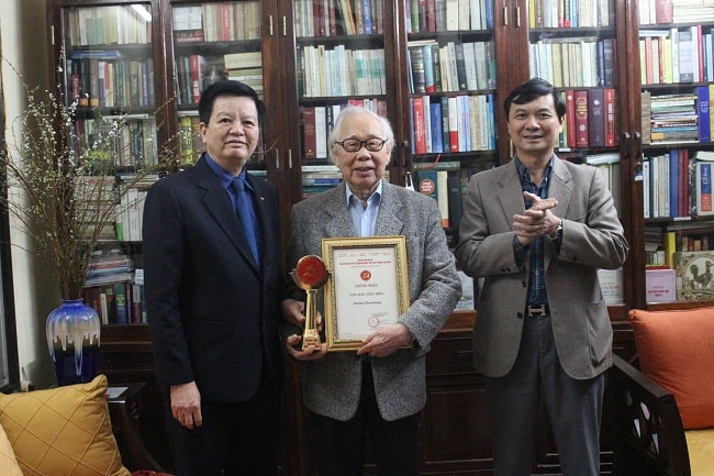 Đồng chí Mai Văn Chính, Ủy viên Trung ương Đảng, Phó Trưởng Ban Tổ chức Trung ương, Trưởng Ban Tổ chức Giải Búa liềm vàng lần thứ V - năm 2020 (bìa trái) trao Cúp và Giấy chứng nhận Nhà báo tiêu biểu cho nhà báo Phan Quang. Ảnh: N.Khiêm
