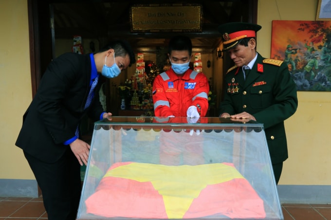 Đồng chí Phan Sỹ Linh, Phó Bí thư Thường trực Đoàn Thanh niên Tập đoàn Dầu khí Quốc gia Việt Nam và cựu chiến binh mặt trận Vị Xuyên kính cẩn đưa lá cờ vào tủ kính lưu trữ tại Đài hương 468.