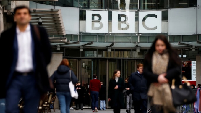 Người đi bộ đi ngang qua logo của BBC tại Broadcasting House ở London. Đài truyền hình dịch vụ công cộng đã bị chặn ở Trung Quốc. © Reuters