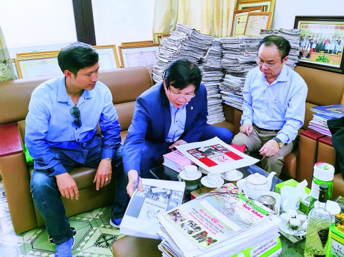 Nhà báo Trần Bá Dung và Phó Chủ tịch Thường trực HNBVN Hồ Quang Lợi trao đổi, sửa chữa từng trang maket sách ảnh “70 năm Hội Nhà báo Việt Nam - Hành trình vẻ vang vì Tổ quốc và nhân dân”.