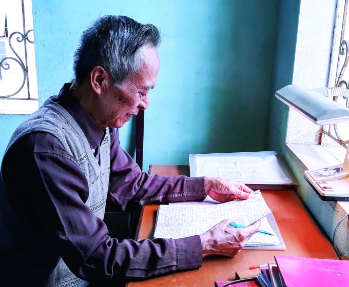 Ông Nguyễn Khắc Nho bên bàn viết.