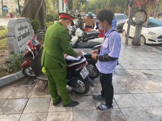 Lực lượng chức năng lập biên bản xử phạt bãi xe trái phép tại khu vực vườn hoa Lý Thái Tổ (quận Hoàn Kiếm, TP.Hà Nội). Ảnh: TL
