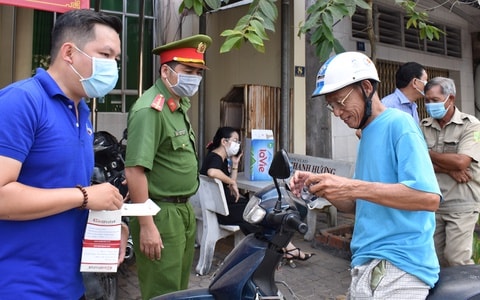 Cảnh sát phát khẩu trang, yêu cầu người dân thực hiện nghiêm các biện pháp phòng dịch Covid-19. Ảnh: Zingnews.vn