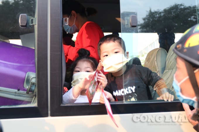 Những đứa trẻ tay cầm lì xì Tết khoe cùng mọi người trên chuyến xe trở về địa phương.