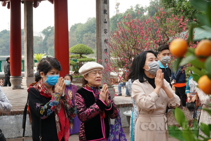 Tuy nhiên bên cạnh đó vẫn còn một số người bỏ khẩu trang ra để chụp ảnh hoặc kéo khẩu trang xuống dưới cằm để lễ,…