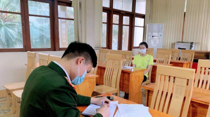 Cơ quan chức năng thị xã Đông Triều (Quảng Ninh) làm việc với nữ công nhân thuê đò vượt sông trái phép từ vùng dịch vào địa bàn Ảnh: Lê Đại