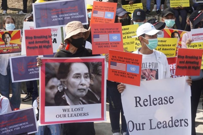 Những người biểu tình giơ các tấm biển có hình nhà lãnh đạo Myanmar Aung Saan Suu Kyi bị giam giữ và yêu cầu thả bà trong cuộc biểu tình phản đối cuộc đảo chính quân sự trước đại sứ quán Mỹ ở Yangon hôm thứ Ba (16/2) - Ảnh: AFP