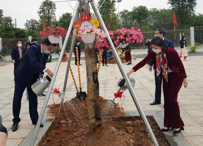 Bí thư Quận ủy Nguyễn Thanh Xuân và Chủ tịch UBND quận Cấn Thị Việt Hà trồng cây trong khuôn viên trường học