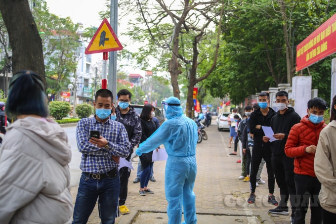 Lực lượng y tế liên tục nhắc nhở người dân đứng xếp hàng theo đúng giãn cách.