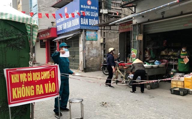 Phát thẻ cho người dân đi chợ theo ngày chẵn lẻ ở TP. Hải Dương. Ảnh: TL