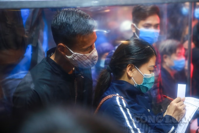 Nhiều người dân tranh thủ ghi vội các tờ phiếu khai báo y tế, thông tin cá nhân để xếp hàng vào mua vàng.