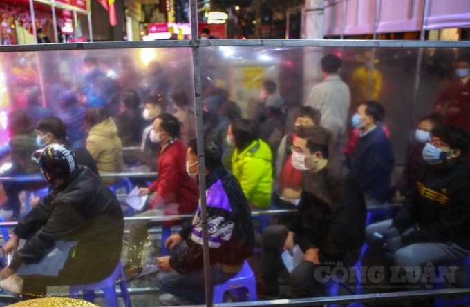 Mọi người ngồi thành hàng chờ đợi thời gian mở cửa hàng để mua vàng.
