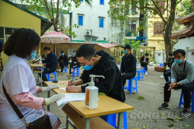 Trước khi vào làm thủ tục, các tân binh sẽ phải đo thân nhiệt, rửa tay sát khuẩn….