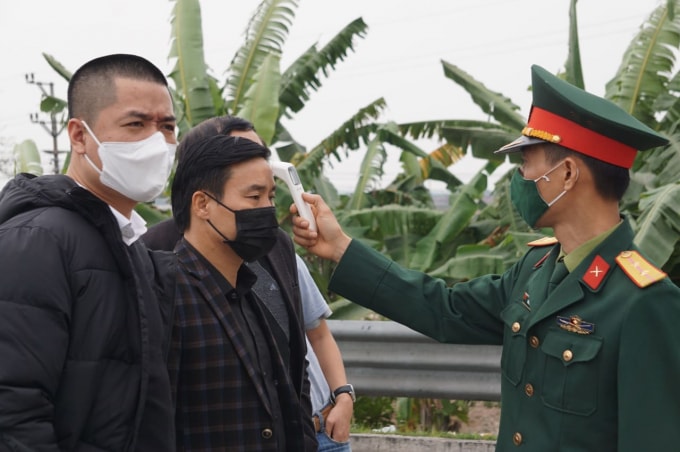 Lực lượng chức năng đo thân nhiệt tại chốt kiểm dịch trên Quốc lộ 5B. Ảnh: V.H