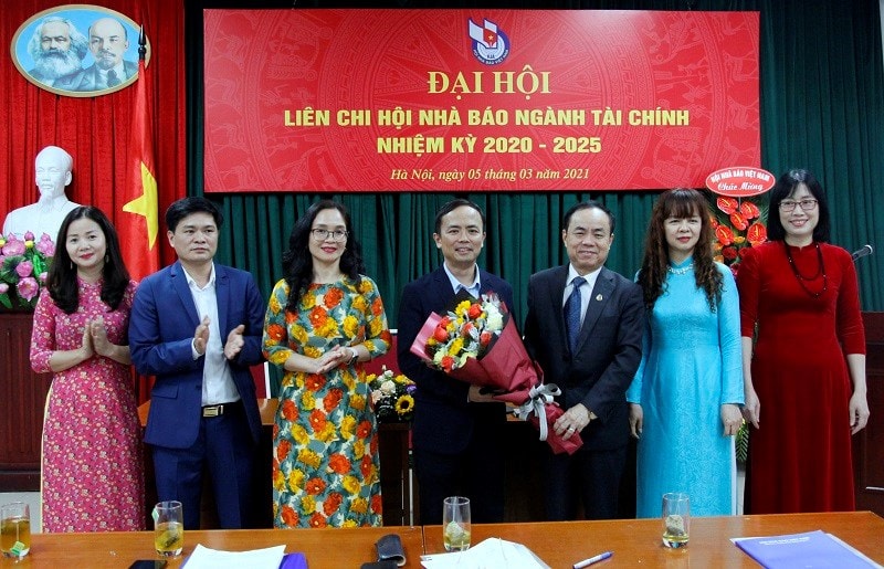 Ông Trần Bá Dung - Ủy viên Ban Thường vụ, Trưởng Ban Nghiệp vụ Hội Nhà báo Việt Nam tặng hoa chúc mừng Ban Chấp hành Liên chi hội Nhà báo ngành Tài chính nhiệm kỳ 2020-2025. Ảnh: Hoài Nam