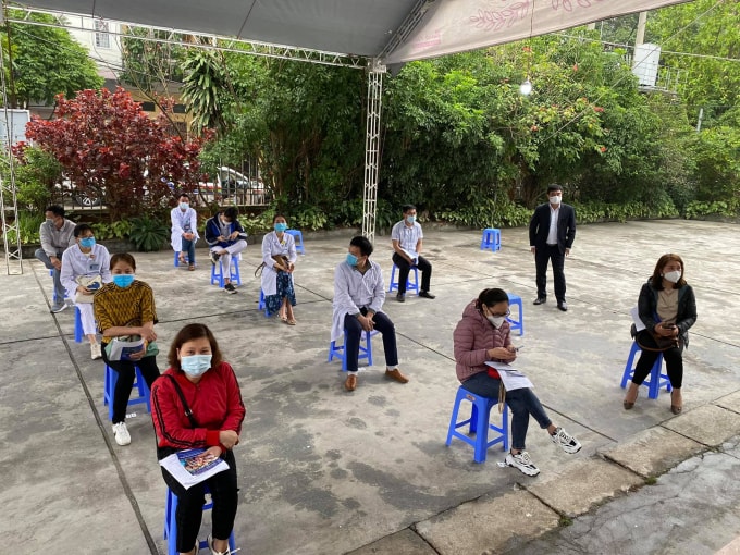 Mọi người tuân thủ quy định phòng dịch 5k tại nơi tiêm chủng (ảnh TL).