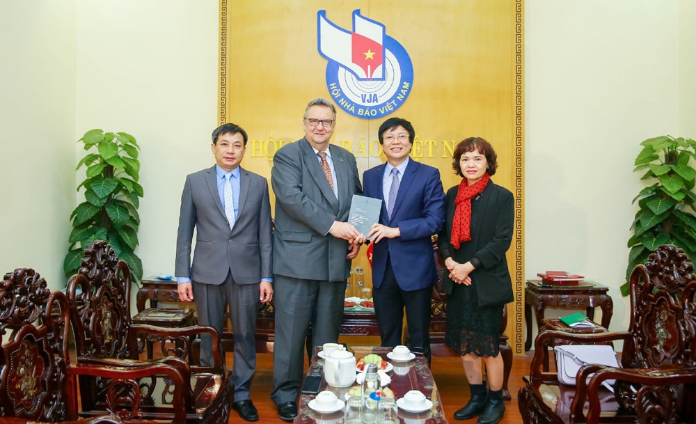 Phó Chủ tịch Thường trực Hội Nhà báo Việt Nam tiếp nhận cuốn sách từ ngài Kari Kahiluoto, Đại sứ đặc mệnh toàn quyền Phần Lan tại Việt Nam. Ảnh: Sơn Hải