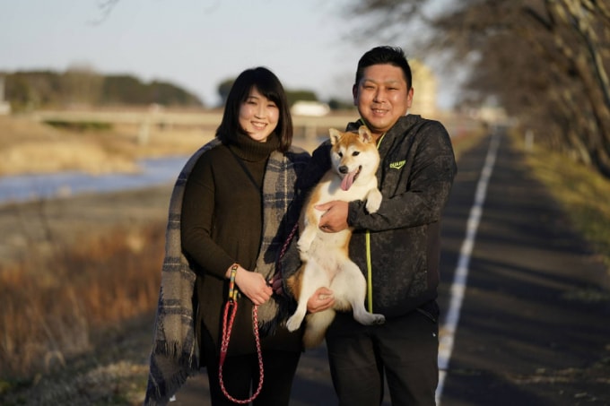Akihiro Zenji và vợ Ryoko dắt con chó của họ, Rin, bên sông Ukedo. | BLOOMBERG