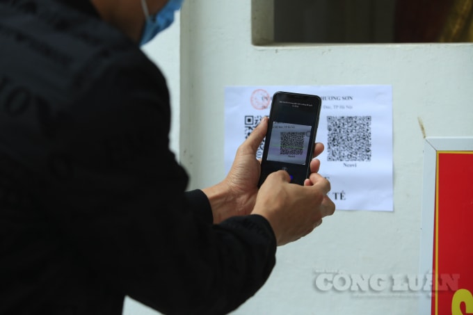 Mọi người quét mã QR khai báo y tế trước khi vào chùa.