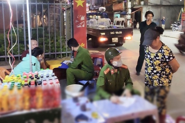 Lực lượng chức năng lập biên bản xử phạt các chủ cơ sở kinh doanh vi phạm quy định phòng chống dịch Covid-19. Ảnh: dantri.com.vn