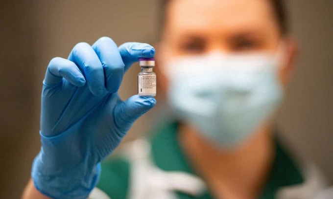Một y tá cầm lọ vaccine Covid-19 của Pfizer và BioNTech. Ảnh: Reuters