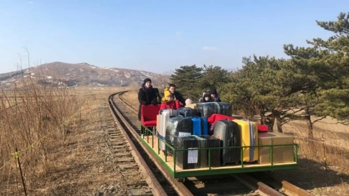Các nhà ngoại giao Nga và các thành viên trong gia đình sử dụng xe đẩy đường sắt bằng tay rời Triều Tiên. Ảnh Kyodo