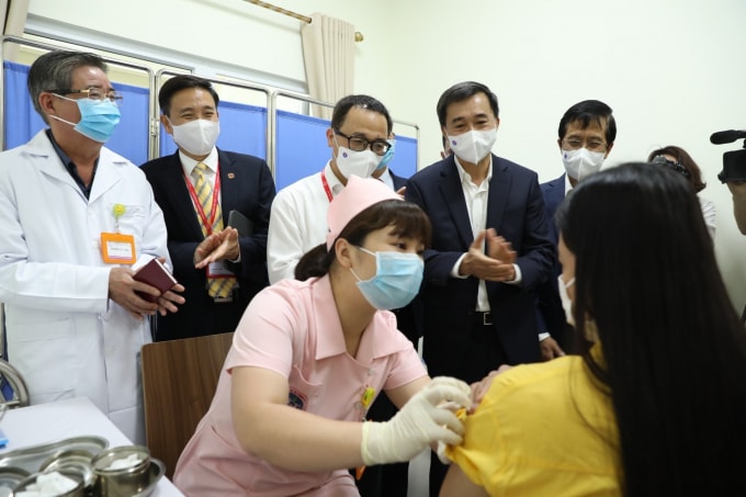 Thứ trưởng Bộ Y tế Trần Văn Thuấn (thứ hai từ phải sang) kiểm tra việc tiêm vắc xin COVIVAC cho một tình nguyện viên - Ảnh: TTXVN